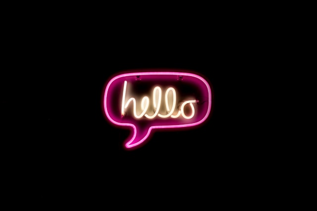 The neon sign "hello" glows in the dark